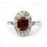 A 14 krt white gold ring. Set with single cut diamonds and an oval facetted garnet, ca. 0.82 ct,