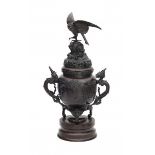 A Japanese bronze koro, with dragon shaped handles and crowned with a phoenix on a rock. 20th