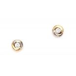 A 14 krt pair of white and yellow gold earrings. Each set with a brilliant cut diamond, total ca.