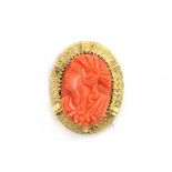 A precious coral cameo depicting a classical female head. In 14 krt yellow gold mount with wire