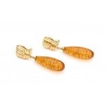 A pair of 14 krt yellow gold earrings. Set with drop shaped heated amber. Gross weight ca. 10.5