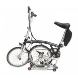 BromptonA black folding bicycle.