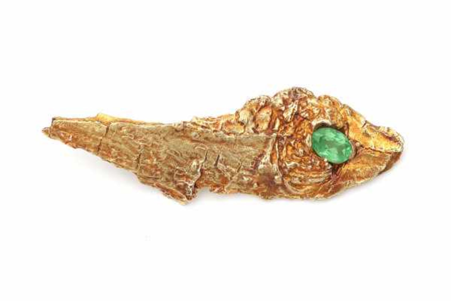 A 14 carat yellow gold brooch of brutalist design. Set with an oval facetted green tsavorite