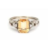 White gold ring set with an emerald cut, yellow topaz of ca. 2.55 ct and two briljant cut