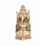 A Hindu ivory sculpture, Ganesh seated on a throne. Dressed in loose robes and with attributes in