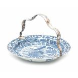 A Chinese blue and white dish with silver handle. Decorated with a peacock in a garden. With