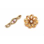 Two 14 carat yellow gold brooches. 19th century. One is set with a rose cut diamond and has diameter