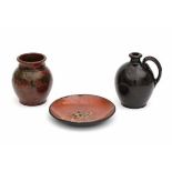 A collection of North American pottery. A black glaze jug, a green and brown glazed jar, and an