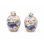 A pair of Chinese blue and white softpaste lidded jarlets, decorated with foo dogs. Marked with