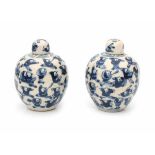 A pair of Chinese blue and white softpaste lidded jarlets, decorated with playing boys. Marked