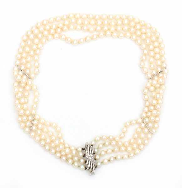 A three strand cultured pearl choker or 'collier du chien' with a 14 carat white gold clasp, set