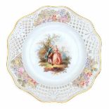 A pierced porcelain plate, decorated with a romantic couple in a landscape. The pierced edge with