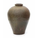 A brown glazed Chinese provincial water jar, with incised pattern. Stamped with a two character