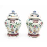 A pair of Chinese famille rose lidded vases, decorated with precious objects and flowers. With