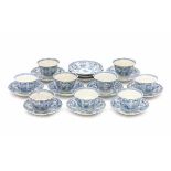 A set of nine Chinese blue and white cup and saucers, decorated with various flowers in panels. With