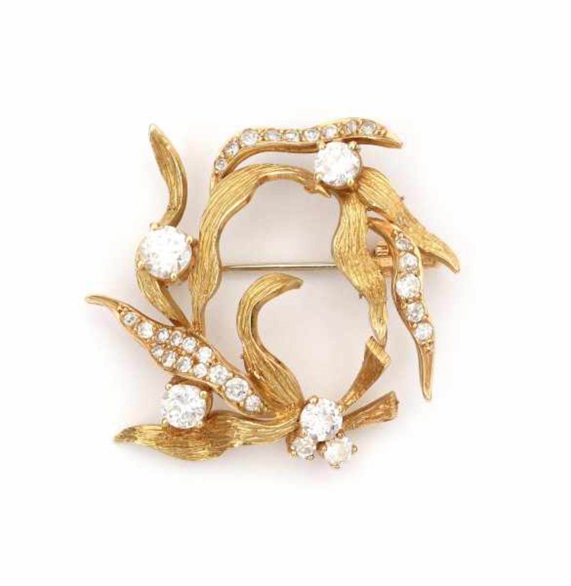 An 18 krt yellow gold circular brooch of floral or leaf design, from the 1970's. Set with