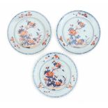 A set of three Chinese Imari plates, decorated with flowers in a rocky garden. 18th