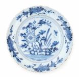 A Delftware blue and white charger, decorated with flowers in a rocky garden. 18th centuryDiameter