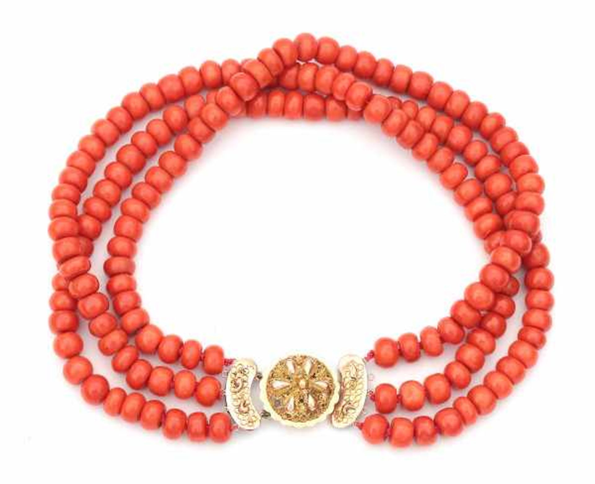 A three strand precious coral necklace with 14 carat rose and yellow gold clasp. The strands are