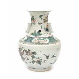 A large Chinese famille verte vase, decorated with birds and insects in a garden scene with
