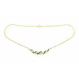 An 18 carat yellow gold necklace. The center is set with baguette and step cut emeralds, total ca.