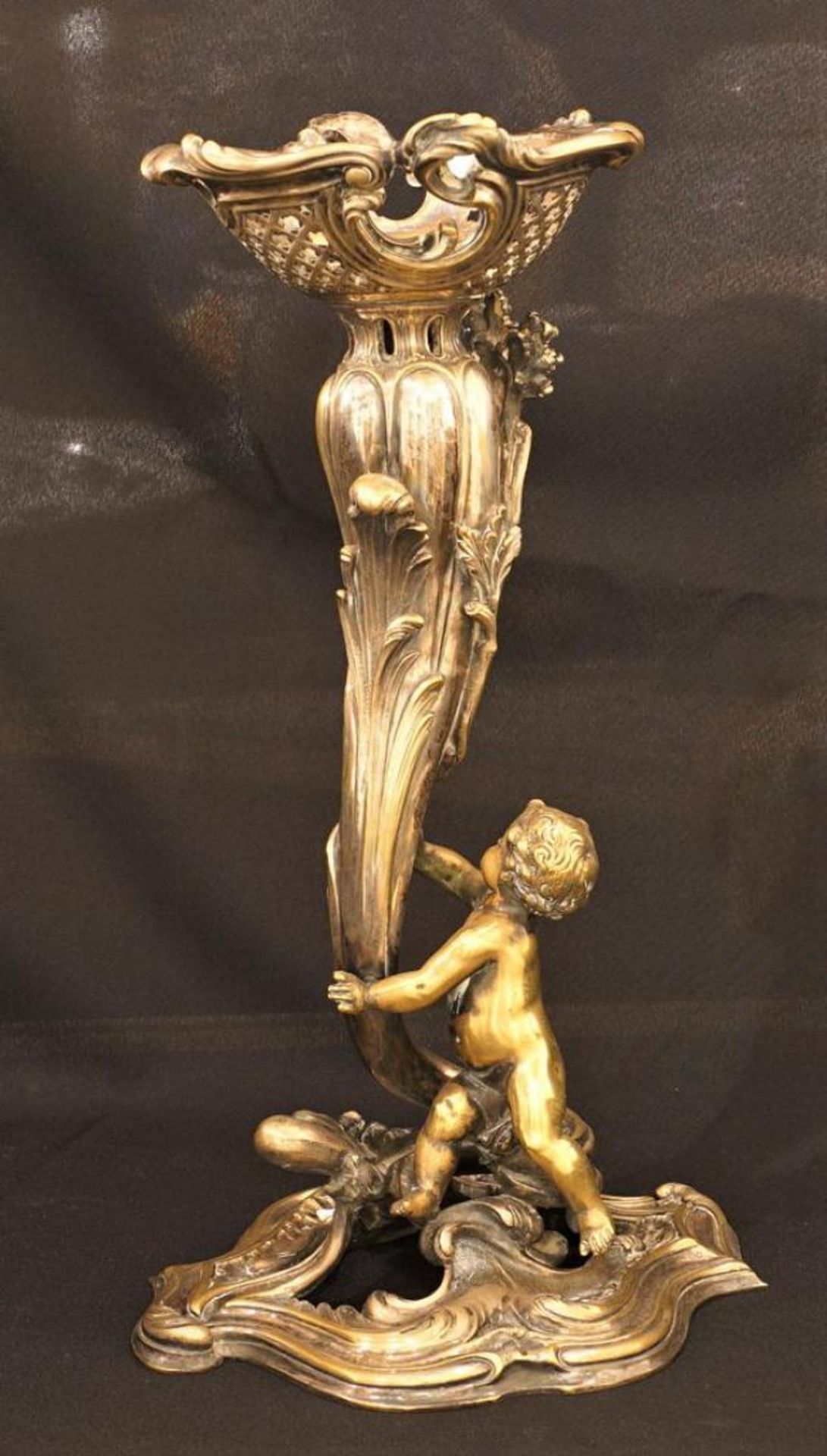 Silver-plated bronze pedestal, 19th century, decorated with a putto, h. 42 cm.