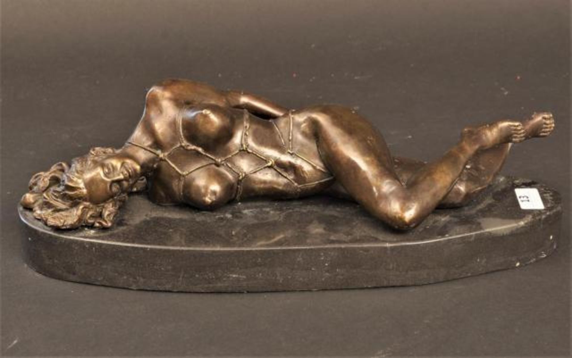 Bronze sculpture on marble base, Nude lying down, l. 34 cm.