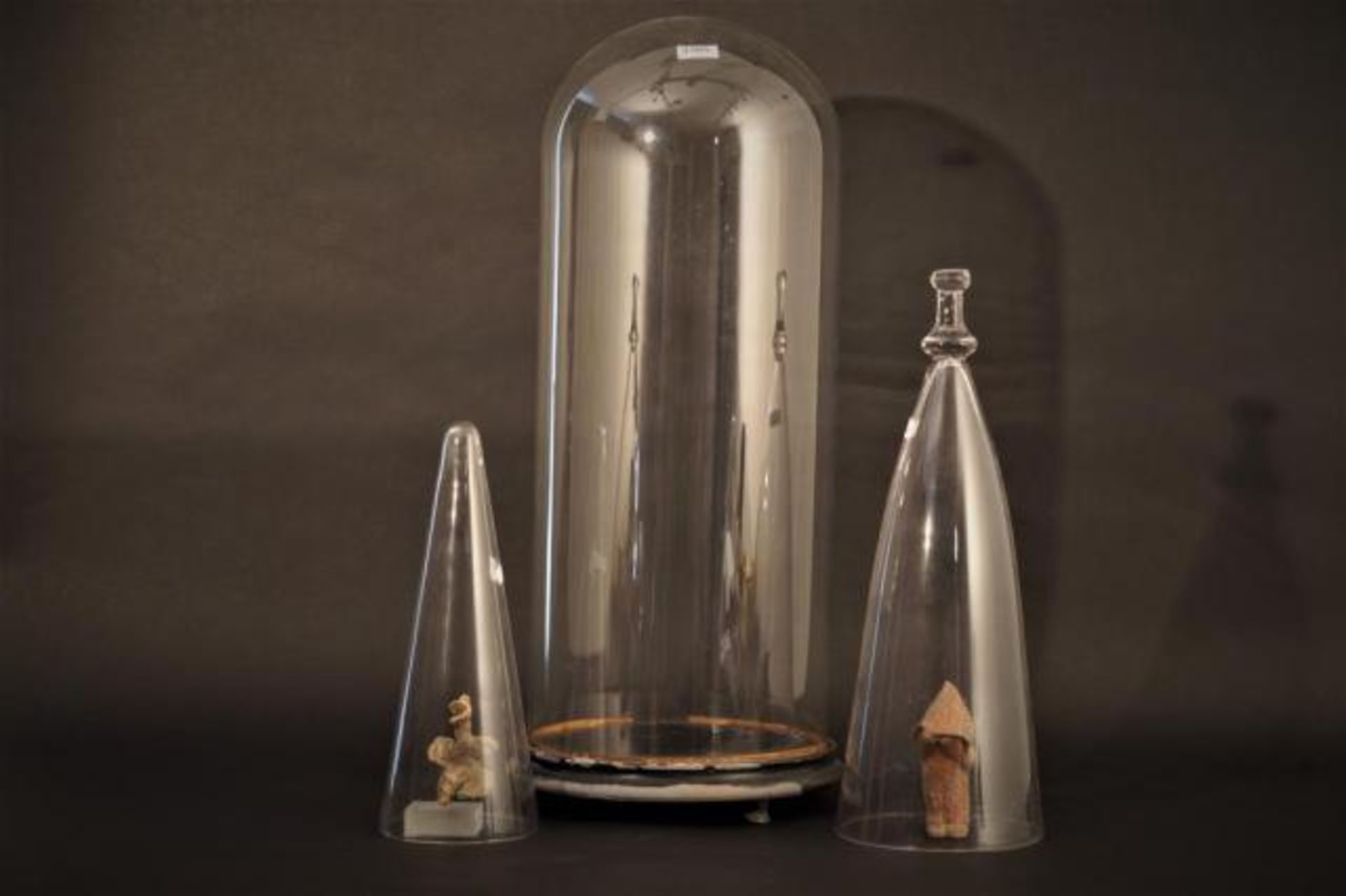 Three glass bell jars, one on a plateau, h. 33, 34 and 64 cm (3x)