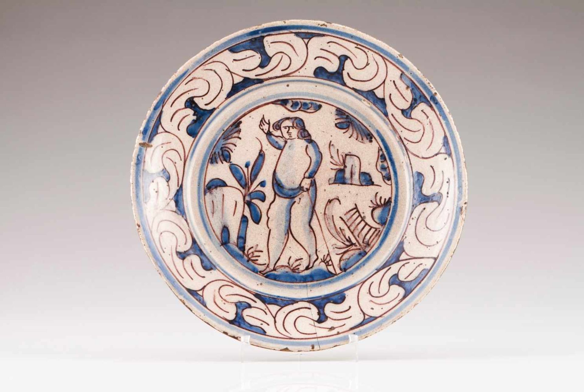 A platePortuguese faienceBlue and vinous decoration depicting landscape with figureTab with