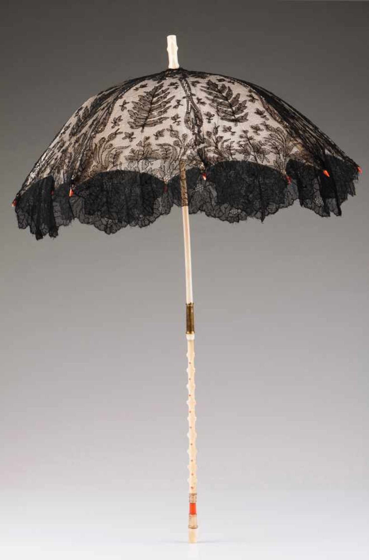 A parasolIvory stem with coral and gold mountsVelvet with black laceFrance, ca. 1860Lenght: 72 cm
