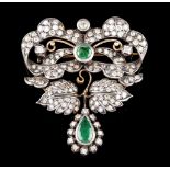 A broochSilver an gold. A bow brooch set with root emerald on a foliage ground and pendant with pear