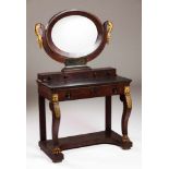 An Empire style dressing tableMahogany and mahogany veneerOval mirror supported by carved and gilt