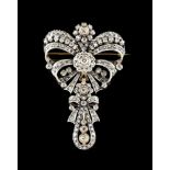 A bow brooch/pendantPortuguese silver and goldThe bow set with 2 brilliant cut diamonds (ca.1.30ct),