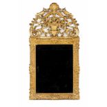 A wall mirror Carved and gilt wood Low-relief foliage scroll decoration Scalloped and carved top