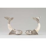 A pair of dolphinsSilver and wild boar tusk sculptures, depicting stylised dolphinsRaised and