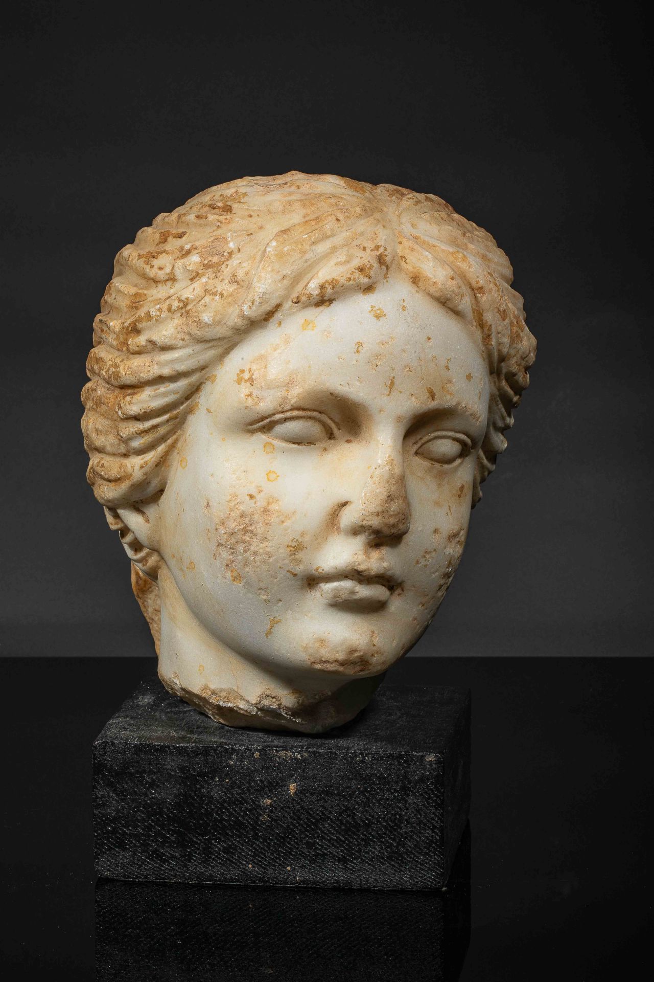 Tête féminine probablement de la Déesse Vénus . Marbre patiné. Epoque romaine. [...]