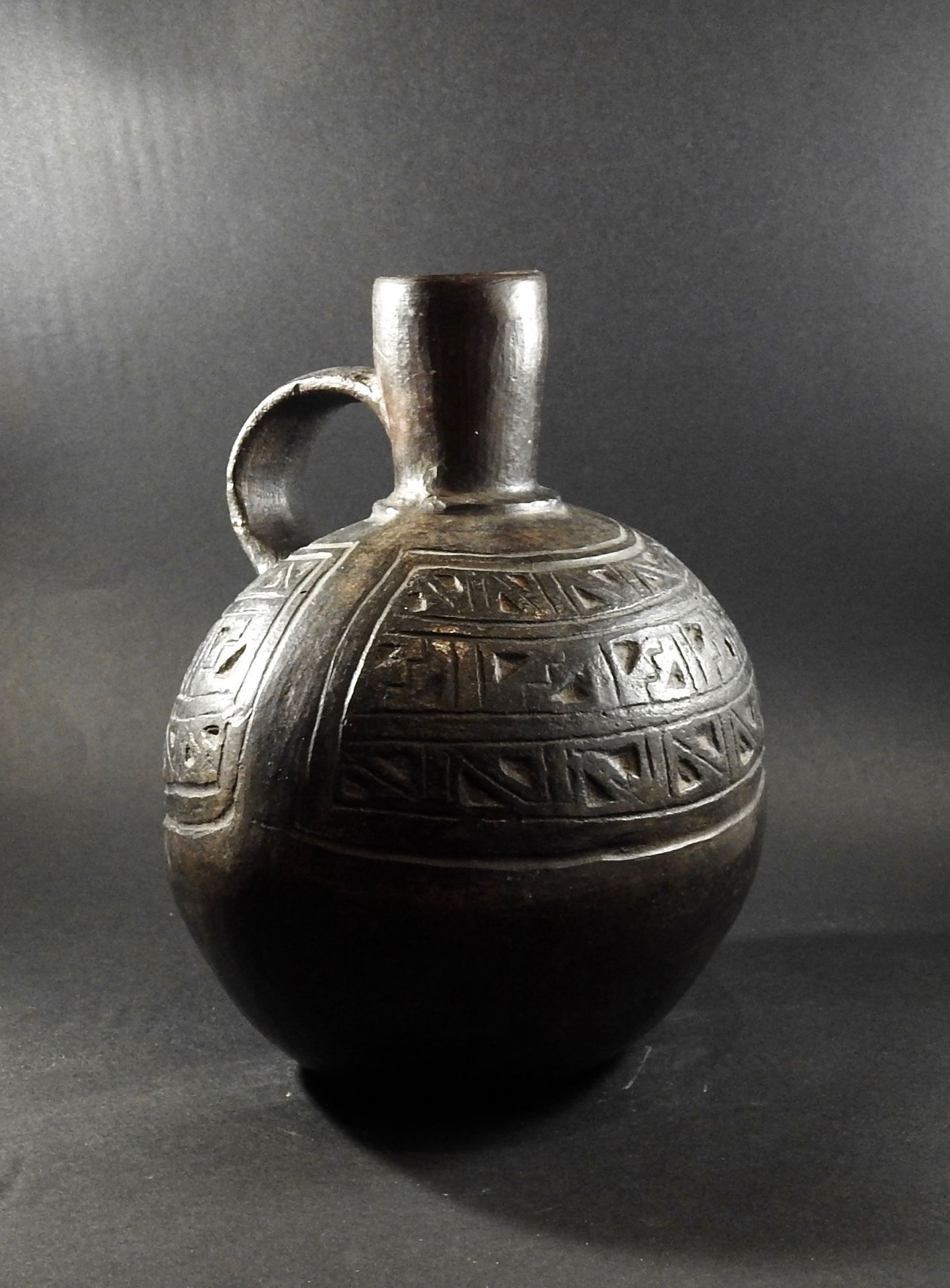 Vase à anse en terre cuite à engobe stannifère. Lacune. - Art préhispanique. H [...]