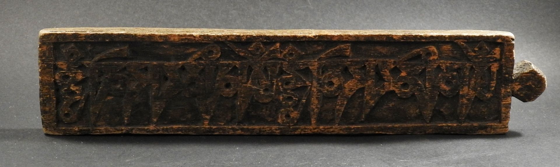 Plaque ornée d’une formule bouddhique. Bois sculpté. Fin XIXès. L :23cm. -