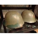 Two vintage steel helmets one with red s