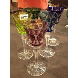 Five Bohemian multi coloured cut crystal wine glasses with faceted stems and star cut bases H: 20
