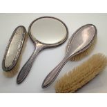 Four piece hallmarked silver dressing table set of three brushes and hand mirror