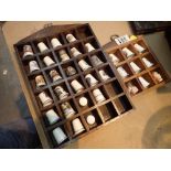 Two wooden thimble display racks and thimbles