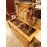 Large smoked glass top coffee table with wicker under shelf and a stained pine towel rack