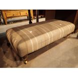 Large upholstered footstool with castors