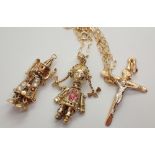 Two 9ct yellow gold articulated clown pendants one with chain and a 9ct gold crucifix 6.