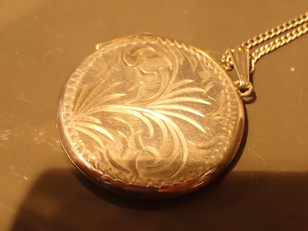 Circular silver locket on chain CONDITION REPORT: Diameter of locket = 3.