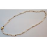 Single strand of pearls having a 9ct gold clasp and ( presumed and unmarked ) gold spacers L: 60 cm