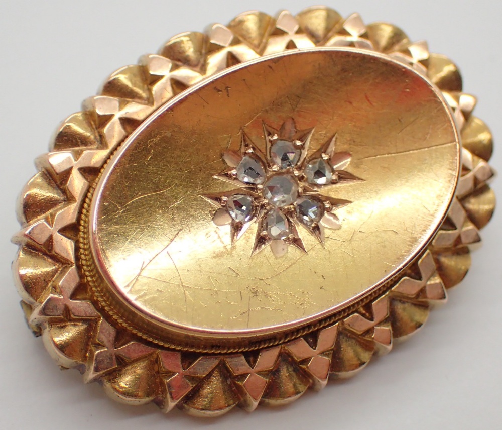 Victorian gold oval mourning brooch set with a cluster of seven old cut diamonds and having glazed