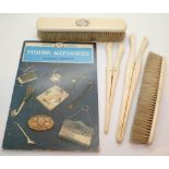 Antique ivory brushes and glove stretchers with fashion accessory book