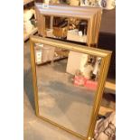 Two bevelled edge wall mirrors in gilt frames with two still life prints